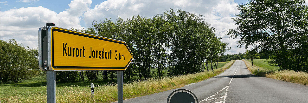 Straße mit gelben Wegweiser: Kurort Jonsdorf 3 km