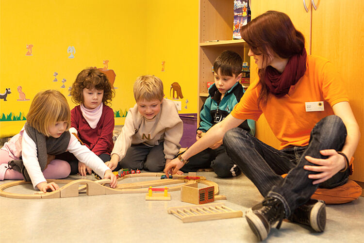 Erzieherin spielt mit Kindern